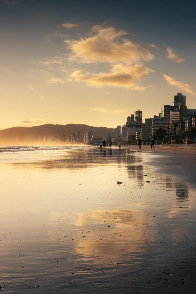 Beautiful sunset view at Itapema beach with city skyline reflecting on the water.